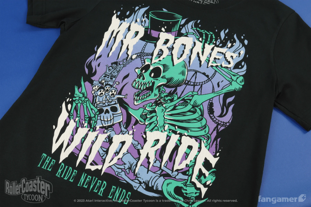The Mr. Bones shirt. The design is white, aqua, and purple inks, and features an enormous smiling skeleton with a top hat looking over terrified people on a roller coaster made of bones