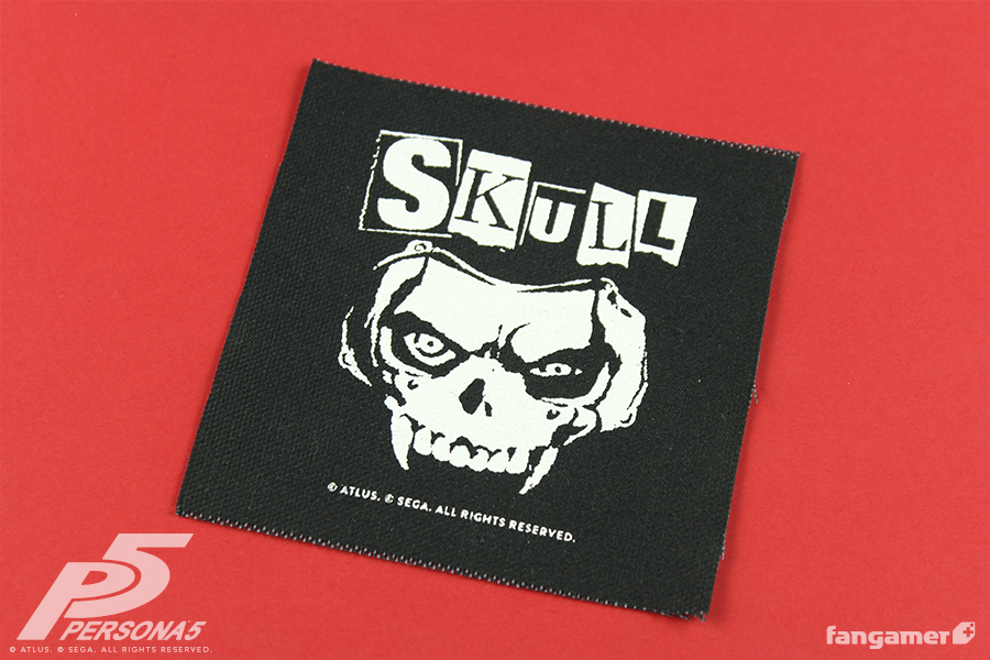 A square patch of Ryuji's skull mask, his eyes peering out from the eye holes. Above it says "Skull" in mismatched cut-out letters