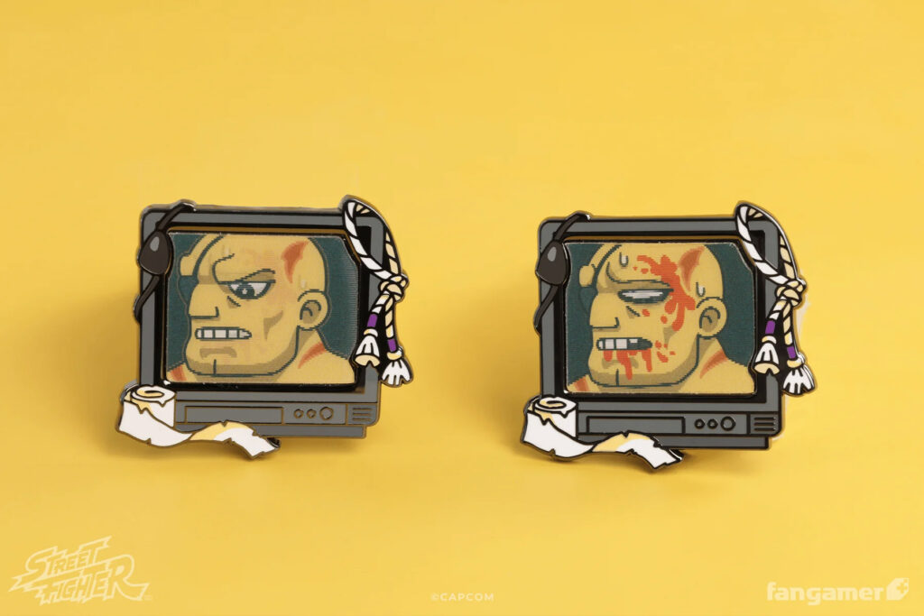 Lenticular pin of Sagat pictured on a TV. His expression changes from intimidating to injured, bloody and defeated.